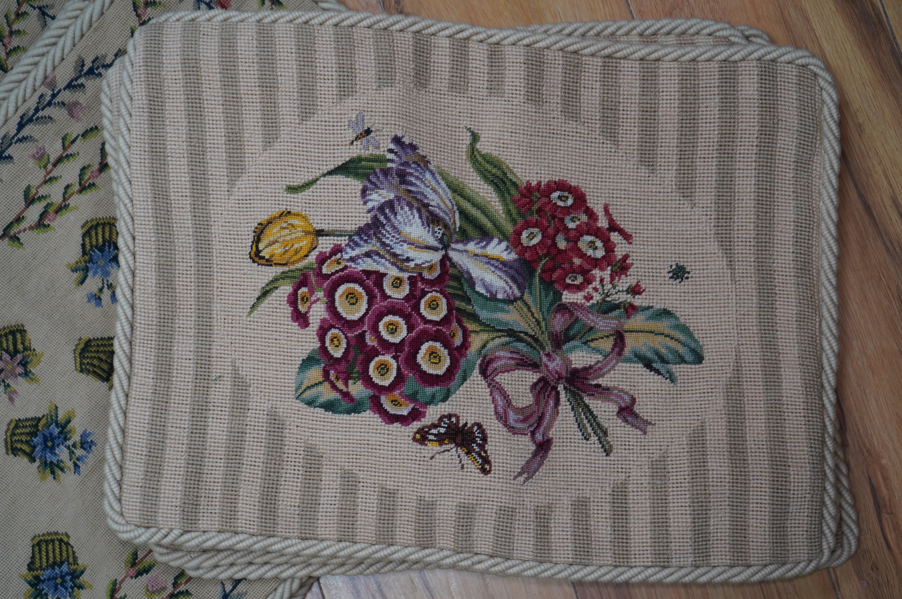 Four floral bouquet and butterfly wool work cushion covers and four similar basket of flowers sprig pattern cushions all edged with mushroom roping, basket sprig pattern 44cm wide, 34cm high. Condition - good
